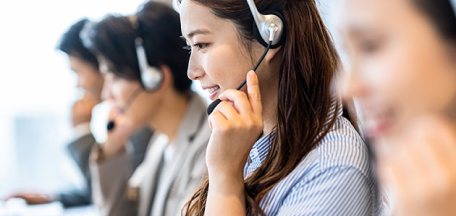 笑顔で対応するコールセンター勤務の女性